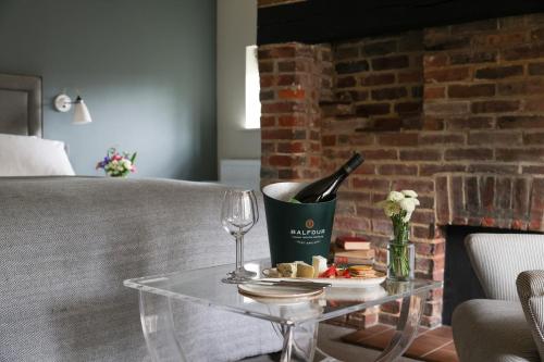a glass table with a bottle of wine and wine glasses at The Swan at Forest Row in Forest Row