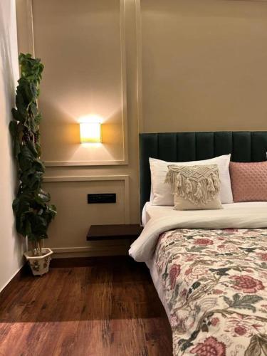a bedroom with a bed with a lamp and a plant at Gulmohar Mansion - A Boutique Stay in Jaipur