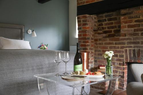 a glass table with wine bottles and wine glasses at The Swan at Forest Row in Forest Row