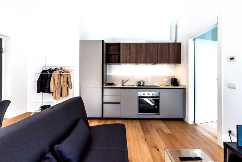 a living room with a couch and a kitchen at Appartamento Vittoria in Legnano
