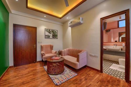 a living room with a couch and a chair and a mirror at Gulmohar Mansion - A Boutique Stay in Jaipur