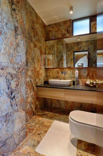 a stone bathroom with a toilet and a sink at Gulmohar Mansion - A Boutique Stay in Jaipur