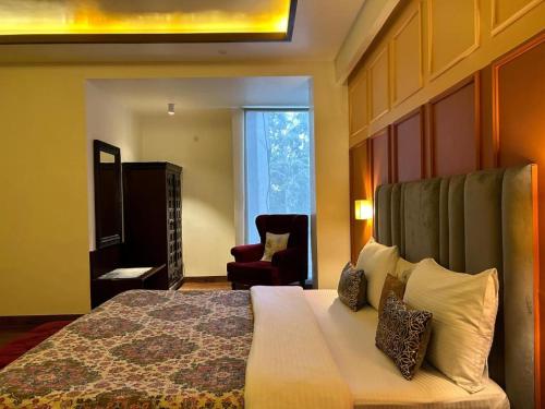 a hotel room with a bed and a chair at Gulmohar Mansion - A Boutique Stay in Jaipur