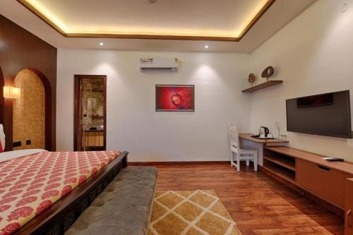 a bedroom with a bed and a desk and a television at Gulmohar Mansion - A Boutique Stay in Jaipur
