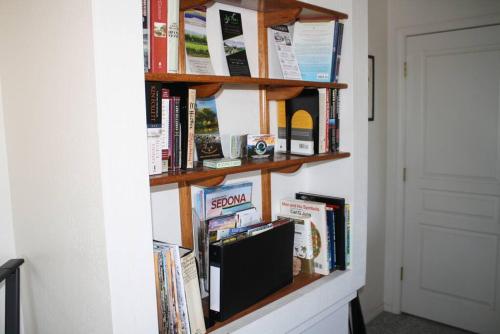 a book shelf with books and a tv on a wall at Quiet in Clarkdale in Clarkdale