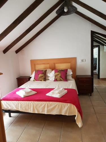 a bedroom with a large bed with a red blanket at Finca Las Minas in Iznájar