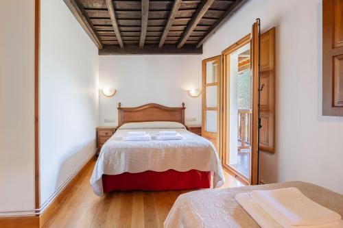 a bedroom with a large bed and a window at La Torre de Perrozo in Cabezón de Liébana