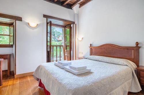 a bedroom with a bed with towels on it at La Torre de Perrozo in Cabezón de Liébana
