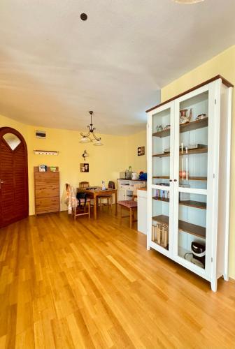 a living room with a wooden floor and a dining room at Heviz Gracia Apartment in Hévíz