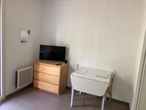 ein kleines Zimmer mit einem Schreibtisch, einem Fernseher und einer Kommode in der Unterkunft ** Studio cosy La Rochelle quartier des Minimes ** in La Rochelle