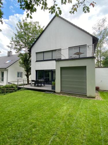 a large white house with a large yard at Modernes Ferienhaus mit 2 Balkonen, Terrasse und Garten ! in Bochum