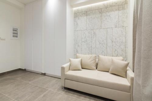 a white couch with pillows in a room at Socrates Fully Equipped Apartments with Unique Design in Athens