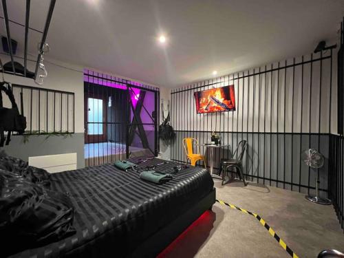 une chambre avec un lit et une table dans une pièce dans l'établissement 50 nuances de gris - BDSM - Loveroom, à Souppes-sur-Loing