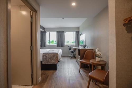 a hotel room with a bed and a desk at Monte Carlo Inn Oakville Suites in Oakville