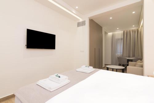 a bedroom with a bed and a tv on a wall at Socrates Fully Equipped Apartments with Unique Design in Athens
