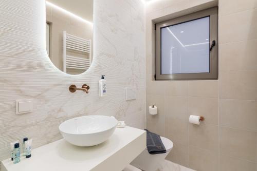 a white bathroom with a sink and a mirror at Socrates Fully Equipped Apartments with Unique Design in Athens