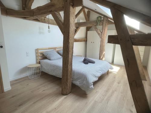 SarragachiesにあるCharmant gîte au calme tout confortのウッドフロアのベッドルーム1室(ベッド1台付)