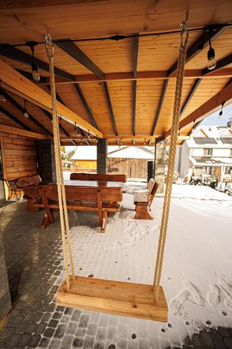 a porch with two benches and a swing at Świerkówka in Siemianówka