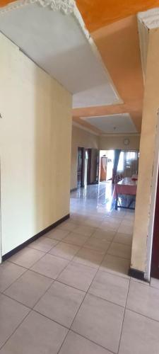 an empty hallway of a building with a tile floor at Vernando Homestay in Bajawa