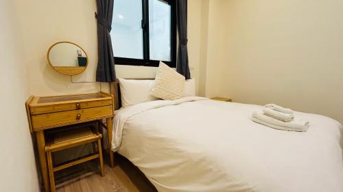 a small bedroom with a bed and a mirror at Full of Fun in Magong