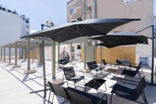 a group of chairs and umbrellas on a patio at Socrates Fully Equipped Apartments with Unique Design in Athens