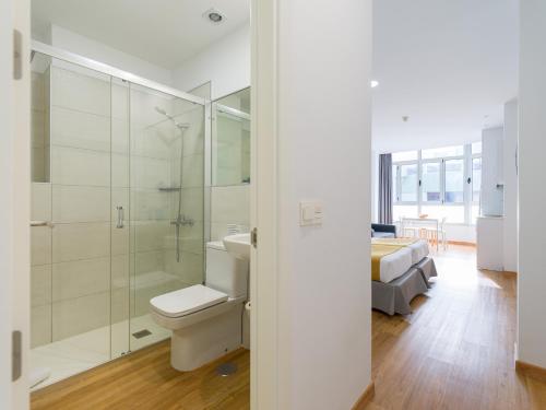 ein Badezimmer mit Toilette und Dusche und ein Bett in der Unterkunft Ok Las Canteras Beach by CanariasGetaway in Guanarteme