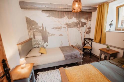 une chambre avec deux lits et un tableau au mur dans l'établissement Gîte du Bief, à Pluvigner