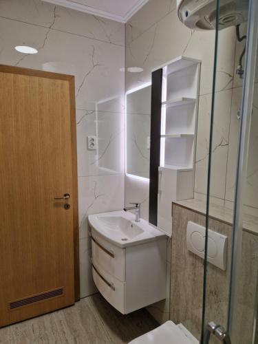a white bathroom with a sink and a mirror at Apartmens Špiko 2 in Hvar