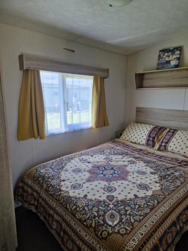 a bedroom with a large bed with a window at 26 Round Piece Lane in Selsey