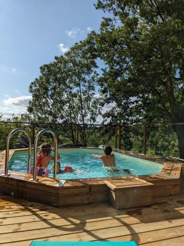 un groupe de personnes dans une piscine dans l'établissement La maison des coteaux - Gîte avec vue d'exception, à Fronsac