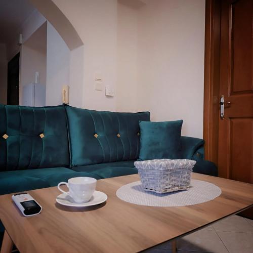 a living room with a green couch and a coffee table at Kosynthos Apartments in Xanthi