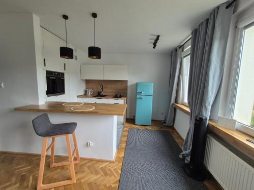a kitchen with a counter and a stool in a room at Klimatyczna kawalerka w centrum No 2 in Gdynia