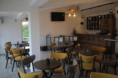 a restaurant with tables and chairs and a bar at Chorev Apartments in Valandovo