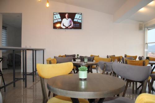 a restaurant with tables and chairs and a tv on the wall at Chorev Apartments in Valandovo