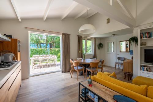 a living room with a yellow couch and a table at Beautifully located dune villa near Noordwijk beach in Noordwijk