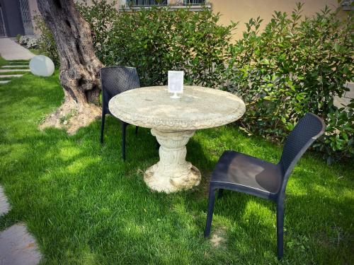 three chairs and a table in the grass at Le Logge del Garda in San Felice del Benaco
