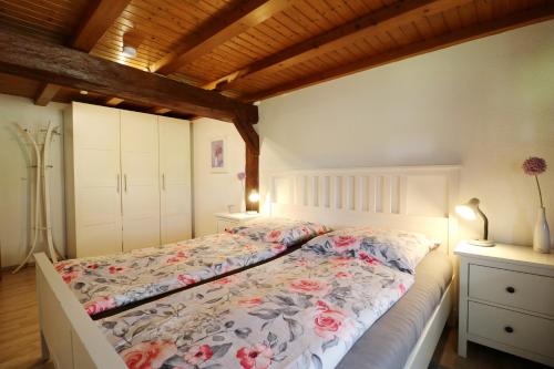 a bedroom with a bed with flowers on it at Schwarzwaldhaus Krebs - Peter Lustig, Lenzkirch, Feldberg in Lenzkirch