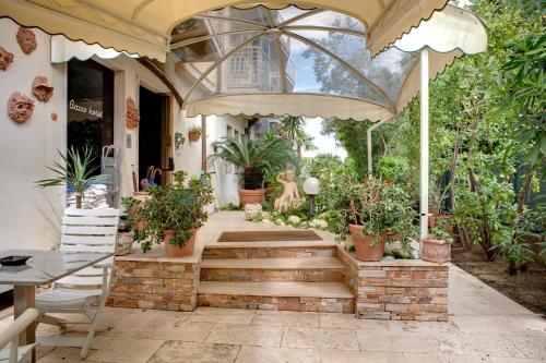 a patio with a large umbrella and potted plants at Hotel Bacco in Lido di Camaiore