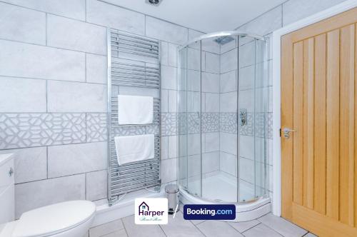 a bathroom with a shower and a toilet at Sleeps 8 Loft bedroom By Harperletting Short Lets & Serviced Accommodation Buckley With Pool table & Long or Short stays in Hawarden