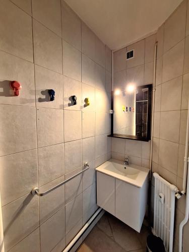 une salle de bain blanche avec un lavabo et un miroir dans l'établissement 2 Appartements 6 personnes Orléans Centre - Proche gare SNCF, à Orléans
