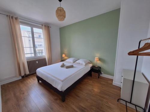 une chambre avec un lit blanc et une grande fenêtre dans l'établissement 2 Appartements 6 personnes Orléans Centre - Proche gare SNCF, à Orléans