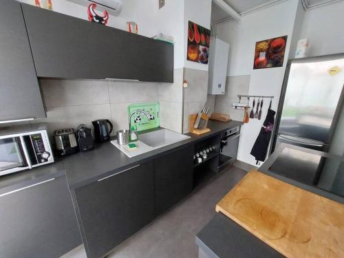 une petite cuisine avec un évier et une cuisinière dans l'établissement Appartement avec terrasse en plein centre-ville, à Marseille