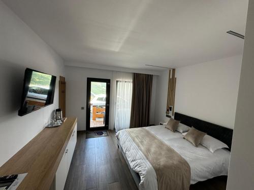 1 dormitorio con 1 cama grande y TV en Panoramic Residence, en Borşa