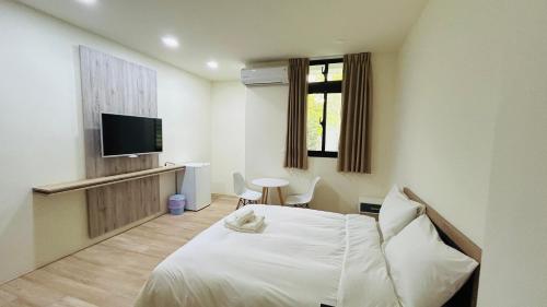 a hotel room with a bed and a television at Full of Fun in Magong