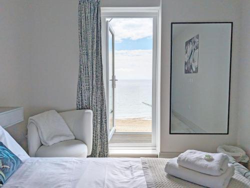 a bedroom with a bed and a window with the ocean at West Lodge, Bognor Regis in Bognor Regis