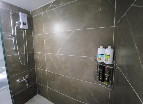a bathroom with a shower with a toilet and bottles of soap at Luxurious Orestis in Limassol