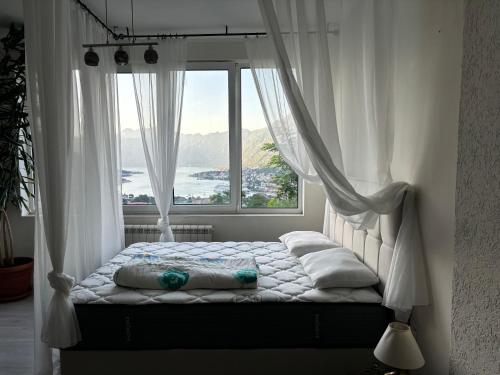 Apartments Vidikovac Inn في كوتور: سرير في غرفة ذات نافذة كبيرة