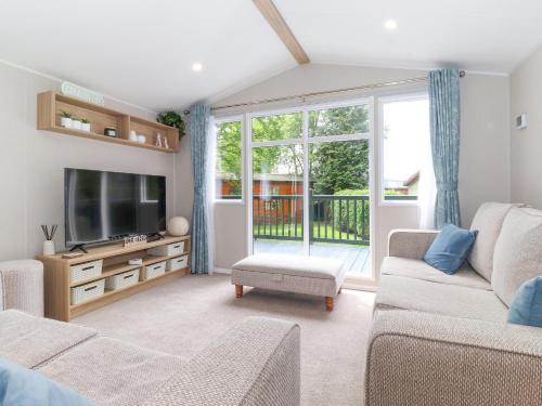 a living room with a couch and a tv at Elton's Escape in Windermere