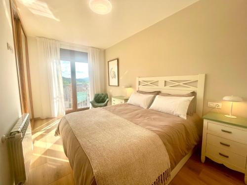 Un dormitorio con una cama y una ventana grande. en Duplex FARO, en Chantada