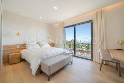 une chambre avec un lit et une grande fenêtre dans l'établissement Villa Gaïa, piscine, vue mer, salle de sport, à Tourrettes-sur-Loup